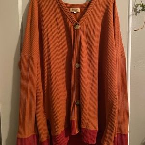 Orange and rusted/red Piko Cardigan in Size Large.